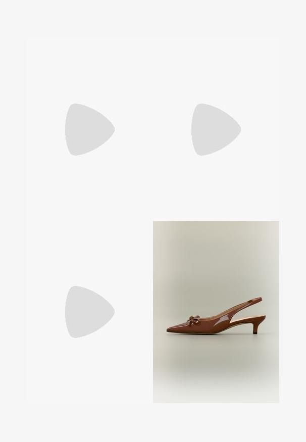 Combinaison en denim avec fermeture éclair à l'avant, col, manches courtes retroussées et ceinture à la taille. Couleur bleu riche avec couture visible et jambes larges.; Chaussure slingback à talon kitten en cuir verni marron, avec bout pointu et petit nœud sur le devant.; Sac à main en cuir verni marron de forme rectangulaire, avec deux longues poignées et des accents courbés subtils à l'avant.; Ceinture en cuir marron enroulée avec une grande boucle ovale en or brillant sur fond blanc.