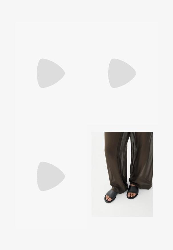 Zwart en crèmekleurig jumpsuit met patroon, korte mouwen, V-hals en elastische tailleband. Stof lijkt lichtgewicht met een vloeiende uitstraling.; Voeten in zwarte slidesandalen gecombineerd met losse, doorschijnende bruine broek tegen een effen witte achtergrond.; Bruine schildpad zonnebril met een vintage cat-eye vorm en bruine lenzen. Heeft gebogen armen met rode accenten.; Zwart leren handtas met een driehoekige vorm, schuine klep en een ronde handgreep. Heeft een gladde textuur en minimalistische ontwerpelementen.
