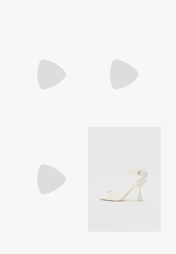 Mono sin mangas de color azul marino con cuello halter, detalle en forma de ojo de cerradura en la parte frontal, cuerpo ajustado y diseño de pierna acampanada en una tela suave.; Sandalía de tacón alto con tiras en cuero blanco, con un diseño elegante, un tacón bloque transparente y un elemento decorativo en la punta.; Clutch rectangular plateado con patrones ovalados en relieve en el frente y una cadena de plata colgada sobre una esquina sobre un fondo liso.; Pendientes de plata con una forma orgánica y abstracta. Superficie lisa y brillante con un diseño cónico. Presentan suaves curvas y un detalle de línea central.