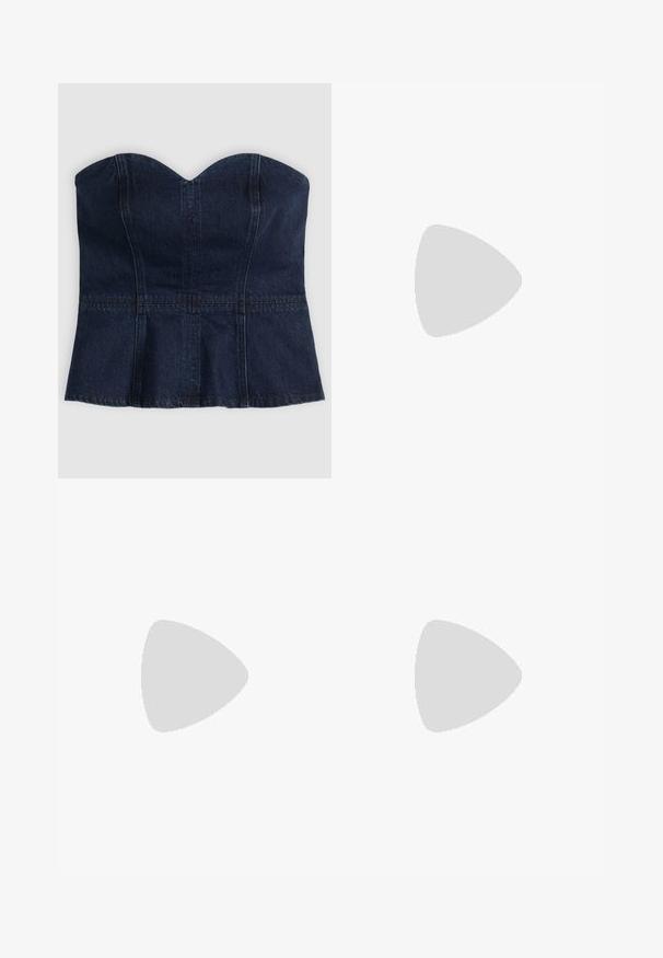 Tmavomodrý bezramienkový denimový bustier s výstrihom v tvare srdca a viditeľnými zvislými a vodorovnými švami.; Džíny s voľným strihom v tmavomodrom denime, s vysokým pásom, piatimi vreckami a kontrastným prešívaním pozdĺž švov a v páse.; Vysoká tmavohnedá kožená kovbojská čižma so šitými dekoratívnymi vzormi, špicatou špičkou a vrstveným blokovým podpätkom.; Žena v čierno-bielom vzorovanom blúzke drží lesklú červenú kabelku cez rameno na jednofarebnom pozadí.