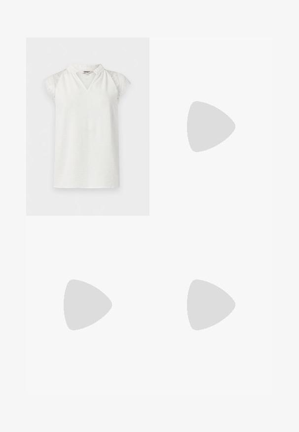 Blouse blanche sans manches avec manches en dentelle et petit col en V à volants, présentée sur un fond uni.; Pantalons larges vert olive avec une texture lisse, dotés de deux boutons dorés à la taille et d'une silhouette épurée et bien ajustée.; Talons slingback beiges en cuir lisse. Présentent un bout pointu, un design découpé et un petit talon cylindrique pour plus de stabilité.; Sac à main en cuir noir de forme arrondie, décoré de clous argentés et équipé d'une poignée courte. Texture lisse et fermeture éclair.