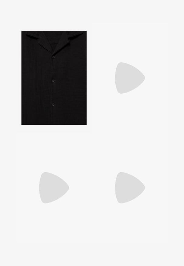 Chemise en tissu noir texturé avec un col cranté et trois boutons noirs visibles sur le devant.; Shorts noirs en tissu texturé, offrant une coupe décontractée, des plis et une taille élastique pour le confort.; Chaussure mocassin en cuir noir présentée en suspension au-dessus d'un tapis beige tissé, avec une table en bois et des livres empilés dans un salon doucement éclairé.; Lunettes de soleil noires rectangulaires avec des verres foncés. Les branches fines et plates présentent un accent doré. Monture en plastique lisse avec une finition mate.