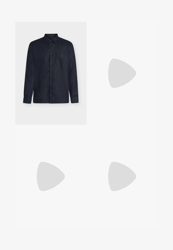 Chemise bleu marine foncé à manches longues avec boutons, col et poche poitrine simple sur fond uni.; Short beige longueur genou avec passants de ceinture, bouton sur le devant et fermeture éclair sur fond clair uni.; Mocassin en daim marron avec semelle blanche et détail métallique, flottant au-dessus d'un tapis clair à côté d'un meuble rond marron brillant.; Ceinture en cuir marron foncé avec une boucle rectangulaire en argent, enroulée et placée sur un fond clair et neutre.