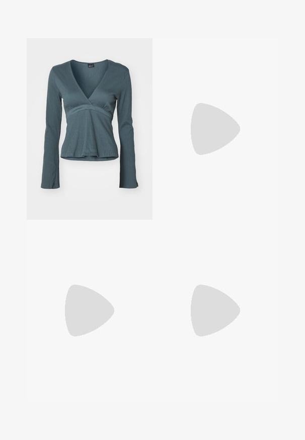 Langærmet indpakningsbluse i dyb teal med en struktureret overflade, der har en V-halsudskæring og en tætsiddende talje, som svagt flares ud ved kanten.; Hvid nederdel lavet af tekstureret stof med rynkedetaljer og bølger. Har en udvidet design med en tætsiddende talje.; Sølvmetallic balletflat med en lille sløjfe på den runde tå og en sort flad sål.; Sølv hoop øreringe med tre lagdelte halvcirkelformede bånd, hvoraf det ene er udsmykket med små klare krystaller på en lys baggrund.