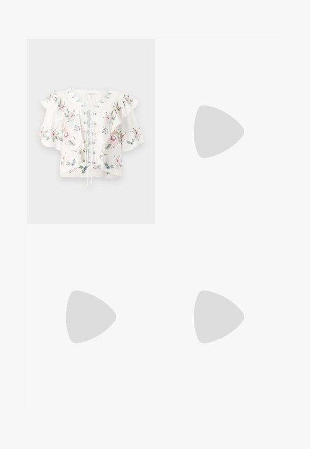 Blouse blanche avec broderie florale, larges manches à volants, encolure festonnée et détail lacé sur le devant.; Jupe trapèze bleu clair avec imprimé tropical de palmiers et de fleurs marron et blanc, longueur genou, avec une ceinture lisse.; Sandale à talon bas de couleur crème avec des liens à nouer autour de la cheville et une large bride torsadée sur les orteils, sur un fond blanc uni.; Sac à main en cuir bleu marine doux avec fermeture à boucle argentée, une seule bandoulière, et une chaîne de poignet amovible sur fond blanc.
