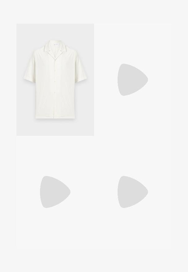 Chemise blanche à manches courtes avec col campagnard et tissu texturé subtil, présentée sur un fond clair uni.; Pantalon beige sur mesure avec plis à l'avant, passants pour ceinture, fermeture à bouton, et un petit détail d'anneau rouge sur le côté gauche.; Mocassin en daim beige flottant au-dessus d'un tapis tissé beige, avec une table basse ronde en bois et des livres empilés en arrière-plan.; Sac bandoulière vert olive en matériau texturé, doté de deux compartiments zippés et d'une marque imprimée en blanc à l'avant. Bandoulière réglable.