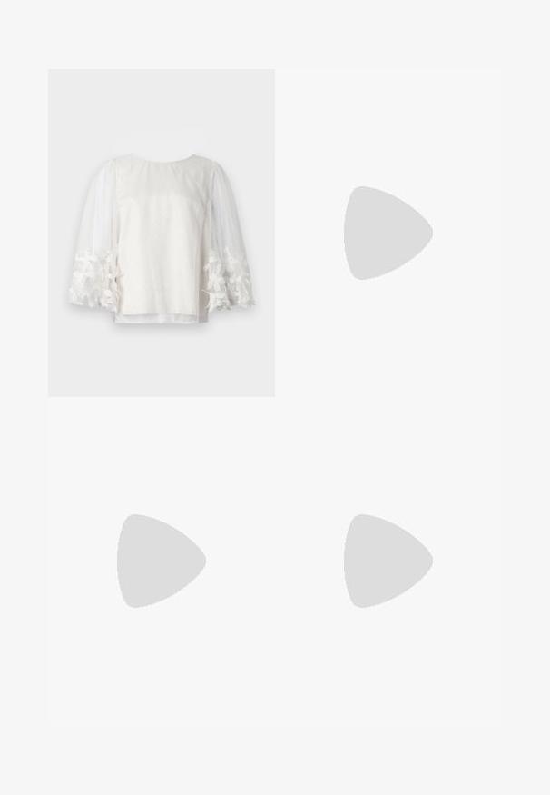 Blouse blanche en voile avec des pois, manches longues bouffantes et poignets brodés de fleurs, présentée sur un fond blanc uni.; Pantalons larges noirs à taille haute, dotés de plis verticaux et d'une fermeture à bouton. Texture lisse, design minimaliste.; Jambes portant des leggings côtelés foncés associés à des ballerines noires avec de petits détails en nœud sur fond blanc.; Petit sac à main noir brillant avec deux longues anses et des détails à cordon sur les côtés sur un fond clair uni.