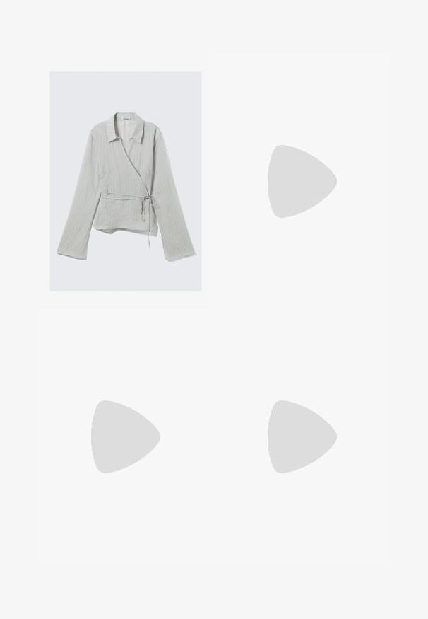 Haut cache-cœur gris clair à manches longues, rayures verticales, col à revers et lien à la taille. Confectionné dans un tissu doux et texturé.; Jupe en jean bleue à volants avec une large ceinture smockée et deux couches froncées sur un fond uni.; Une sandale flip-flop beige unique avec de fines brides sur un fond blanc uni, vue de profil.; Bracelet en mesh doré avec une texture lisse, doté d'un fermoir sécurisé et d'une gravure subtile. Design simple et circulaire avec une finition brillante.