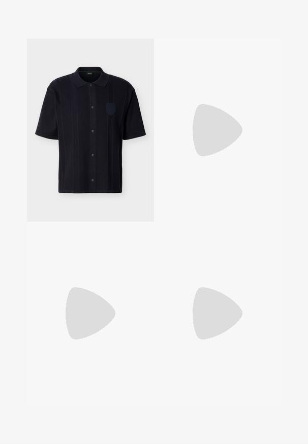 Chemise noire à manches courtes avec des rayures verticales texturées, un col et un petit badge sur la poitrine côté gauche.; Pantalon bleu marine en mélange de coton. Présente une coupe droite, une fermeture à bouton sur le devant et de légères plis. Texture douce.; Baskets en cuir bleu marine avec une semelle crème, dotées d'une fermeture à lacets, d'une pointe arrondie et d'éléments de design minimalistes incluant des accents ton sur ton.; Bracelet à maillons en métal argenté avec une fermeture plate, comportant des maillons rectangulaires et arrondis en motif répétitif.
