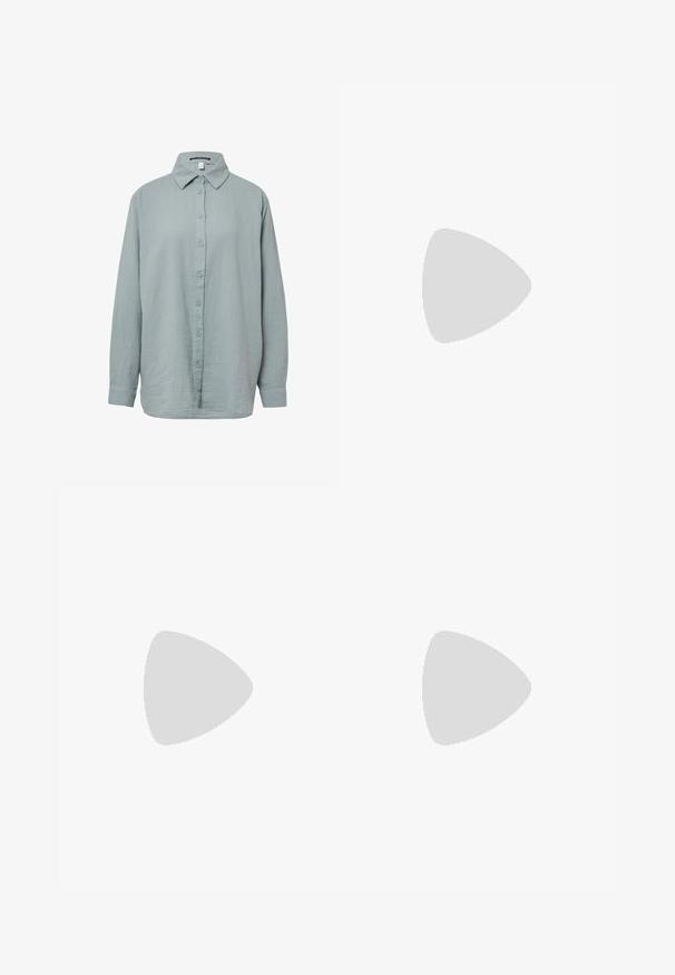 Chemise à manches longues, bleu clair, à boutons. Fabriquée en tissu doux et texturé avec un col standard, dotée d'une fermeture à boutons sur le devant et de manches à poignet.; Jean large en denim bleu clair avec taille haute, deux poches avant et coutures visibles. Fermeture à bouton et à zip.; Des pieds portant des sandales Birkenstock beiges avec des boucles dorées, associées à un jean en denim bleu foncé retroussé aux chevilles, posés sur un sol en bois.; Sac à main blanc plissé avec poignée courte et une large bandoulière amovible texturée avec boucle argentée.