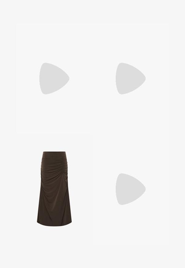 Polo-shirt à manches longues marron foncé avec six boutons noirs et un petit logo brodé sur la poitrine gauche.; Jupe midi marron avec des détails froncés sur le côté droit, cintrée à la taille et s'évasant légèrement vers l'ourlet.; Bottine en daim marron à talon bloc avec un accent doré sur un sol gris réfléchissant près d'un mur en blocs de verre.; Sac bandoulière en cuir marron avec une bandoulière chaîne dorée, petit logo "C" doré et une étiquette en cuir attachée au matériel de la bandoulière.
