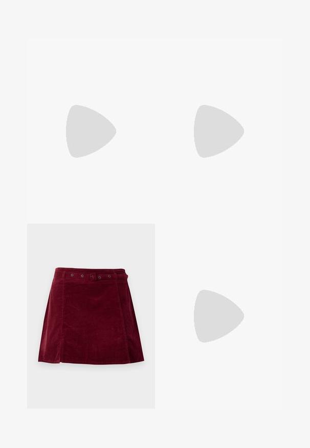 Haut en satin rouge avec un design froncé, comprenant de longues lanières à franges à l'avant et à l'arrière, et une texture lisse. Bretelles de cou réglables incluses.; Jupe en velours côtelé rouge foncé avec une ceinture assortie et des œillets métalliques, présentant une légère forme trapèze et un détail sur le panneau avant.; Escarpin en cuir verni bordeaux à talon haut, avec un bout pointu, une bride de cheville et un talon épais. Texture lisse et design élégant.; Femme portant un chemisier à motif noir et blanc tenant un sac à main rouge brillant sur un fond uni.