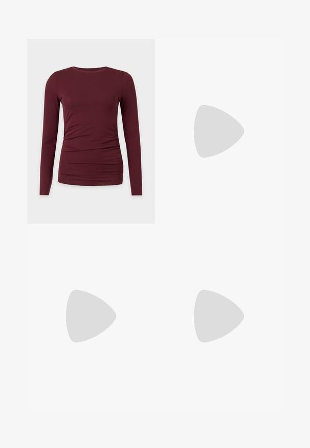 Chemise bordeaux ajustée à manches longues avec un léger froncé sur un côté, encolure ronde, présentée sur fond blanc.; Jeans en denim gris délavé taille haute avec cinq poches, fermeture à bouton et coupe droite relaxée.; Chaussure plate en cuir noir avec un nez pointu, des détails froncés autour de l'ouverture et un accent en boucle argentée sur la bride ajustable.; Petit sac à main noir brillant avec deux longues anses et des détails à cordon sur les côtés sur un fond clair uni.
