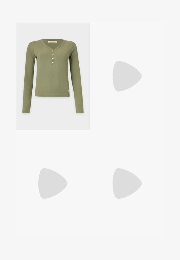 Langemouws olijfgroene geribde henley met vier witte knopen en een klein dierenlogo vlak bij de onderzoom.; Hoge taille, wijde pijpen, donkerblauwe denim jeans met een sluiting van voor knoop en rits, riemlussen en voorzakken.; Benen met donkere geribbelde leggings gecombineerd met zwarte ballerina's met kleine strikdetails op een witte achtergrond.; Zwarte leren schoudertas met gespsluiting aan de riem, afgeronde hoeken en contrasterende witte stiksels op een effen achtergrond.