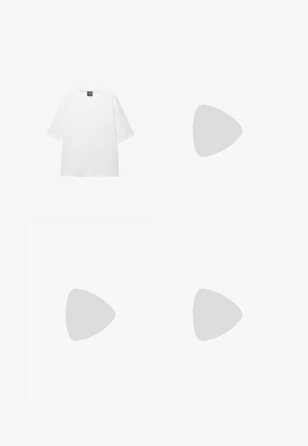 Hvid oversized t-shirt med korte ærmer, rund halsudskæring og blødt bomuldsstof. Har et sort mærke ved halsen. Ingen mønstre eller accenter.; Sorte shorts lavet af stof med en glat tekstur, der har en frontknaplukning, to sidelommer og et plisseret design.; Sort læderloafer svæver over en skinnende sølvfarvet, polstret lædersofa i et minimalistisk miljø.; Ray-Ban solbriller med grønne linser, sorte plastikstel og gyldne detaljer ved kanterne. Firkantet form med mat finish.