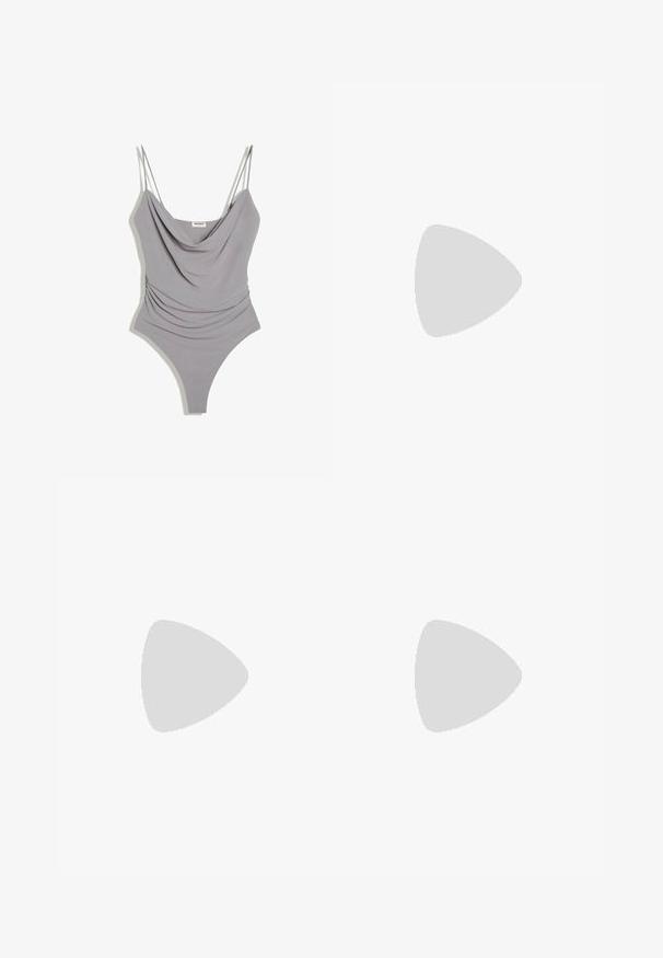 Hellgrauer ärmelloser Body mit dünnen Trägern und drapiertem Ausschnitt, gestaltet mit gerafften Seiten und einem Tanga-ähnlichen Unterteil.; Braune, hoch taillierte, enganliegende Sportshorts mit V-förmigem Nahtdetail am Bund, dargestellt vor weißem Hintergrund.; Blaue Wildleder-Sneaker mit weißen Schnürsenkeln und einem karierter Seitenpaneel. Verfügt über eine braune Gummisohle und goldene Logodetails.; Drei dünne Goldketten locker aufgerollt vor weißem Hintergrund, die ihre feine, reflektierende Textur hervorheben.