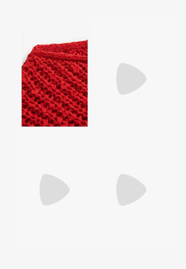 Gestrickter roter Stoff mit einem strukturierten, offenen Design. Das Material wirkt leicht und flexibel und weist durchgehend Schlaufen und Muster auf.; Cremfarbene weite Hose mit hohem Bund, fünf Taschen, Metallknopf und Stoffschleifen, die entlang beider Hosenbeine gebunden sind.; Brauner und beiger Nike-Sneaker mit Mesh- und reflektierenden Details schwebt über einer Betonkante vor einem verschwommenen grauen Hintergrund.; Braune Leder-Umhängetasche mit einem einzigen Riemen, kleinem goldenen Coach-Logo vorne und einem passenden Lederanhänger, der am Riemen befestigt ist.