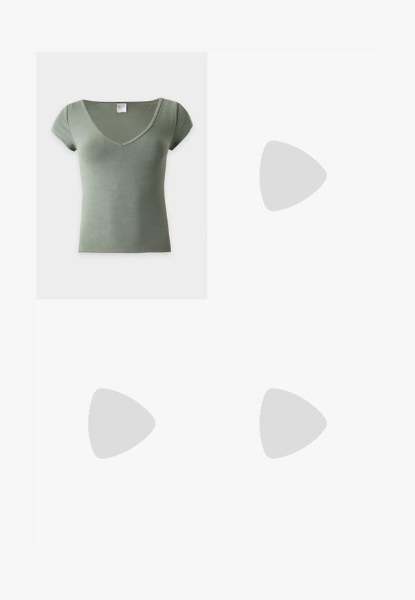 Top en maille côtelée verte à manches courtes, avec un col en V profond et une silhouette ajustée, présenté sur un fond clair uni.; Jean en denim bleu clair taille haute, bouton à l’avant, texture délavée et jambes évasées larges.; Jambes portant des leggings côtelés foncés associés à des ballerines noires avec de petits détails en nœud sur fond blanc.; Petit sac à main noir brillant avec deux longues anses et des détails à cordon sur les côtés sur un fond clair uni.