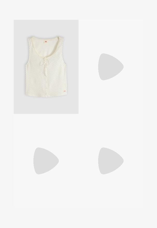 Witte mouwloze blouse met kleine zwarte stippen, knopen aan de voorkant, ronde halslijn met strik en subtiele kanten afwerking rond de hals.; Licht paarse shorts van zacht materiaal met een elastische tailleband en een relaxte pasvorm, met een eenvoudige, onversierde uitstraling.; Enkele roze instapschoen met goudkleurige gesp en zwarte zool die boven een beige gestructureerd tapijt zweeft, met een houten salontafel en boeken op de achtergrond.; Gevlochten strooien tas met gevlochten handvatten en een rood-wit geruit lint dat aan één zijde in een strik is gebonden.