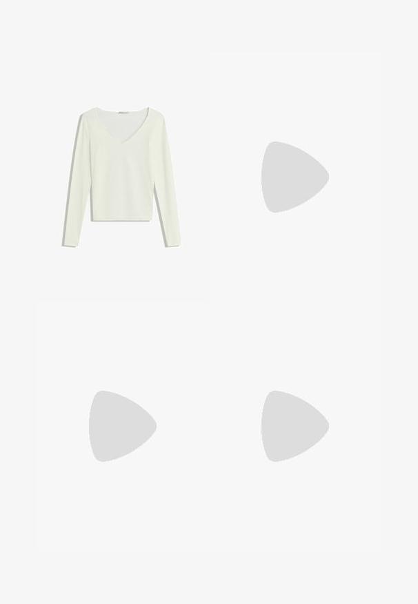Haut en tricot côtelé blanc à manches longues, avec un décolleté en V et une coupe courte, présenté à plat sur un fond blanc.; Jeans en denim bleu à jambes larges avec poches avant, passants de ceinture et fermeture par bouton, posés à plat sur un fond clair.; Chaussure slip-on en daim marron avec un bord en rouge et crème à motifs, semelle texturée et logo UGG sur le côté. Présente une légère hauteur de plateforme.; Sac à main en daim marron foncé en forme de croissant avec une seule sangle large et une texture lisse sur fond blanc.