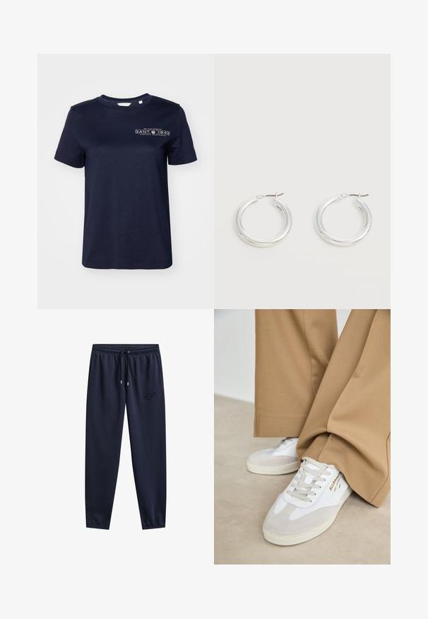 Camiseta de algodón azul marino de mangas cortas, con cuello redondo y un logo impreso que presenta "GANT 1949" en el lado izquierdo del pecho. Textura suave.; Pantalones deportivos azul marino con cintura elástica, cordón, bolsillos laterales, piernas estrechas y un sutil logo bordado en el muslo derecho.; Zapatillas blancas con detalles de ante, cordones texturizados y suela de goma. Combinadas con un pantalón suelto en tono marrón claro. Logo exhibido en el lateral.; Par de pendientes de aro plateados brillantes de tamaño mediano con cierres metálicos finos sobre un fondo neutro claro.