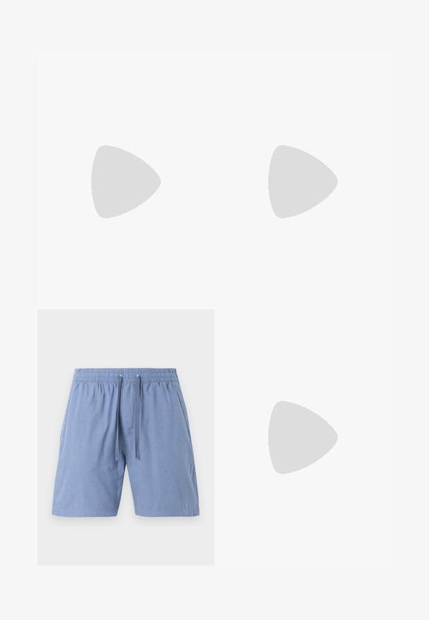 Camiseta azul de algodón con mangas cortas y cuello redondo, con el logo blanco "CK" en el pecho izquierdo. Textura lisa, corte regular.; Shorts de color azul claro con cintura elástica y cordón. Tienen bolsillos laterales y una tela ligeramente texturizada.; Mocasín de cuero negro brillante con detalle de correa, colocado sobre una alfombra beige cerca de una mesa de café redonda marrón en una habitación con iluminación suave.; Gafas de sol negras con lentes rectangulares, acabado mate, montura gruesa y brazos delgados con un discreto detalle de marca.