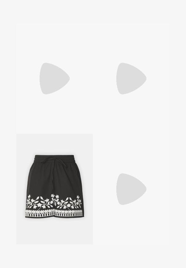 Kvinde står mod en lys trævæg iført en lyserød kattemotiveret t-shirt, sorte sportsshorts, sorte slip-on sandaler og bærer en sort taske med prikker.; Sorte shorts med hvid blomsterbroderi og kant. Har en snor i taljen og let stof, ideelt til afslappet brug.; Sorte spidse ankelstøvler med en glat læderoverflade, lave blokhæle, og parret med hvide brede bukser. Enkel og moderne design.; Sort lakeret håndtaske med dobbelte top-håndtag, aftagelig skulderrem, rund form og et fremtrædende præget "PUMA"-logo.
