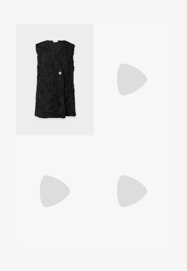 Veste sans manches en dentelle noire avec motif floral et une seule fermeture à bouton en argent sur le devant.; Robe maxi noire sans manches avec bretelles spaghetti et détail en dentelle florale sur le corsage, cintrée à la taille avec une jupe fluide.; Jambes portant des leggings côtelés foncés associés à des ballerines noires avec de petits détails en nœud sur fond blanc.; Petit sac à main noir brillant avec deux longues anses et des détails à cordon sur les côtés sur un fond clair uni.