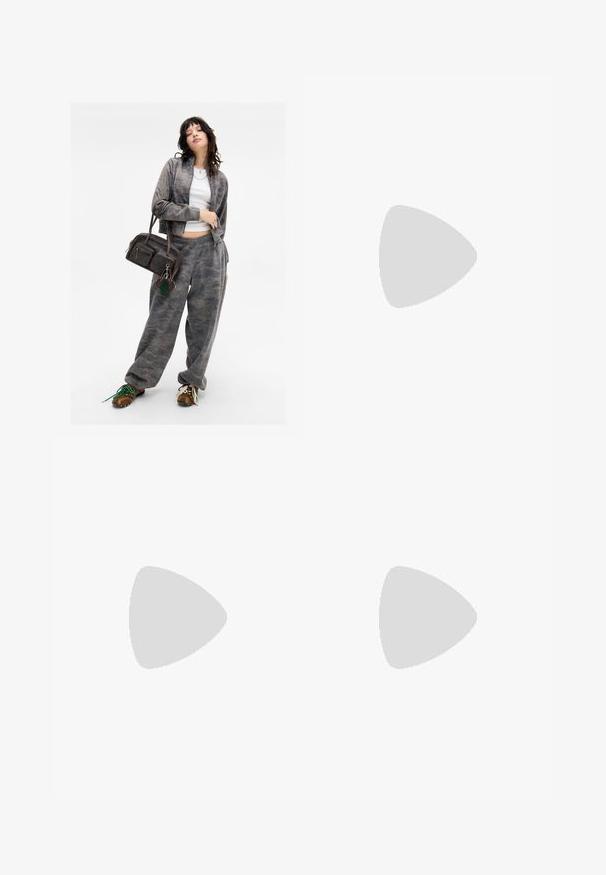 Grijze camouflagepatroon zip-up jack met bijpassende sweatpants. Bruine handtas met twee ritsvakjes en een groen sleutelhangeraccent. Bruine schoenen.; Crème t-shirt met korte mouwen en een ronde halslijn, gemaakt van zacht materiaal, met een rechte snit en minimale details.; Uitlopende denim jeans in een vervaagde blauw tint met een klassiek vijf-pocket ontwerp, featuring een lichte textuur en zichtbare stikaccenten.; Taupe suède enkellaars met een slouchy ontwerp, spitse neus en een slanke hoge hak. Beschikt over een zachte textuur en subtiele stikseldetails.; Zwarte leren geweven schoudertas met een ronde handgreep en een maansvormig lichaam op een effen achtergrond.