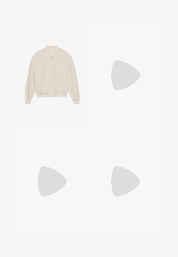 Witte zip-up sweatshirt met ribbeltextuur, ribbelmanchetten en -zoom, zijzakken en een klein gouden logo-opaccent op de borst.; Witte katoenen t-shirt met een ronde hals, korte mouwen en een subtiele logodetail op de voorkant. Inclusief een klein rood label aan de zijkant.; Lichtblauwe denim wijde jeans met een hoge taille, voorzien van vijf zakken, riemlusjes en een zachte, licht vervaagde textuur.; Sportschoenen met een bovenkant van grijs suede en mesh, rode accenten en een gewatteerde witte zool. Geribde witte sokken zijn gedeeltelijk zichtbaar.