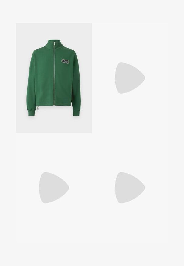 Grøn zip-up sweatshirt med ståkrave, fremstillet af blødt stof, med et lille mærke på venstre bryst og ribbede manchetter.; Kortærmet t-shirt lavet af blødt stof, med en ferskenfarvet bund og et geometrisk rødt mønster samt et lille grønt logo på brystet.; Lys grøn sweatpants med elastisk talje, tapered ben og manchetter ved anklerne. Lavet af blødt, let væv. ; Grønne ruskindsneakers med en hvid gummisål, der har en hvid tung og snørebånd, samt et diskret logo med "EST. 1933" på siden.