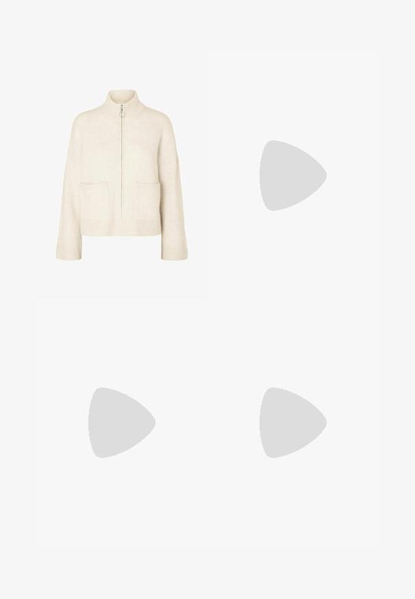 Suéter creme curto com colarinho alto, fecho frontal e dois bolsos à frente. Feito de um tecido de malha suave com detalhes canelados.; Blusa branca com riscas verticais, gola alta adornada com detalhes texturizados e mangas longas bufantes que terminam em punhos ajustados.; Calças bege ajustadas com um design de perna reta, feitas de um tecido leve. Apresenta pregas frontais e uma cintura clássica.; Sapatilhas brancas em malha com detalhes em prata e uma sola texturizada, posicionadas sobre uma superfície vermelha, combinadas com calças à quadrados.