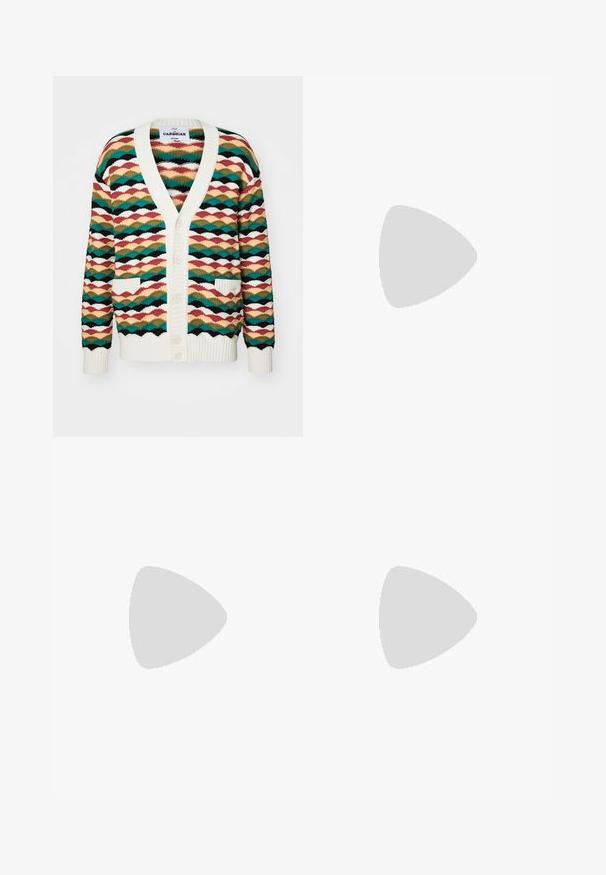 Färgglad cardigan med ett vågmönster i nyanser av grönt, rött och krämfärgat. Den har en v-ringning, två framfickor och ribbade kanter.; Svart kortärmad oversized T-shirt med rund halsringning och synlig Filippa K-märkesetikett inuti kragen.; Mörkblå bomullsbyxor med rak bendesign, frontknappstängning och klassisk midja med bälteshällor.; Ljust beige läder sneakers med platta snören, en strukturerad yta och en kontrasterande gummisula i krämfärg, parat med svarta avsmalnande byxor.
