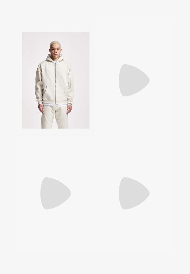 2Y Studios Felpa con zip - off white; T-shirt bianco di cotone con maniche corte. Presenta un testo ricamato blu navy "Mickey's" e una grafica di pizza. Collo a giro semplice.; Pantaloni beige a taglio dritto, con un solo bottone nero, passanti per la cintura e tasche laterali. Tessuto dalla texture liscia e design minimale.; Zoccoli neri in pelle con punta rotonda, dettagli con cintura e fibbia, e una soletta in sughero, dotati di una suola in gomma testurizzata.; Occhiali da sole neri con lenti rettangolari, montatura in plastica opaca e bordi dritti. Presentano il logo del marchio sulla parte interna del braccio.