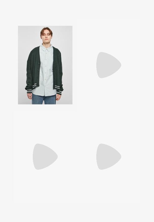 Dunkelgrüner Strickcardigan mit gerippter Textur, mit durchgehender Knopfleiste, weißen Streifenakzenten an den Bündchen, getragen über einem hell gestreiften Hemd.; Graues Baumwollmix-T-Shirt mit schwarzem Nike-Logo; verfügt über ein kleines Nike-Etikett am seitlichen Saum; schlichtes Design, kurze Ärmel.; Beige Cargo-Hosen aus leichtem Baumwollmaterial. Mit elastischen Bündchen, mehreren Seitentaschen und einem Knopfverschluss.; Weiße Leder-Sneaker mit Perforationen, runder Zehenpartie, flacher Sohle und dicken Schnürsenkeln, mit sichtbar eingesticktem Swoosh-Logo und "AIR" an der Ferse.