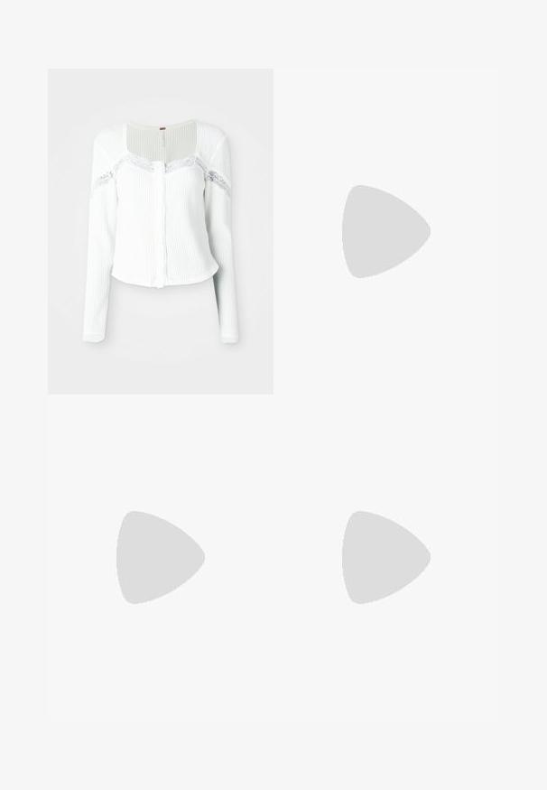 Vit långärmad cardigan gjord av texturerad tyg, med spetsdetaljer längs axlarna och knäppning framtill.; Svart kortärmad topp i slät tyg; har en draperad halsringning och asymmetrisk nederkant, med en figursydd kropp.; Svarta byxor med rak passform, utrustade med framfickor och sidoklyvningar vid fållen. Tillverkade av mjukt, slätt tyg. Lämpliga för olika tillfällen.; Svarta lackerade klacksandaler med fyrkantig tå, ankelremmar och silverfärgade spännen. Har en kraftig blockklack för stabilitet.