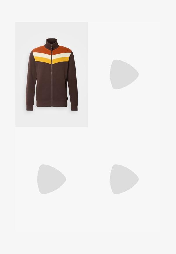 Braune Reißverschlussjacke mit hohem Kragen, die ein geometrisches Design in Orange, Weiß und Gelb über den Schultern aufweist. Glatte Textur.; Weißes T-Shirt mit kurzen Ärmeln in gerippter Textur. Runder Ausschnitt, lockere Passform, keine sichtbaren Muster oder Akzente. Einfaches und vielseitiges Design.; Beige weite Hose mit elastischem Bund und Kordelzug. Sanfte Textur, zwei seitliche Taschen und minimale Nähte für eine entspannte Passform.; Weiße Sneakers mit glatter Textur, versehen mit braunen Lederakzenten und schwarzen Details, kombiniert mit schwarzen maßgeschneiderten Hosen. Hintergrund aus Holzboden.
