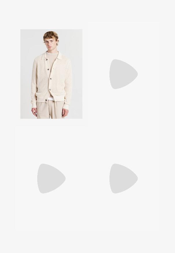 Helle beige Strickjacke mit einem strukturierten Muster, großen Knöpfen und einem Kragen, kombiniert mit einem cremigen Oberteil darunter.; Weißes Baumwoll-T-Shirt mit Rundhalsausschnitt, kurzen Ärmeln und lockerer Passform. Hat ein schlichtes Design ohne Muster oder Akzente.; Beige gerade geschnittene Jeans aus Denim, mit einem klassischen Fünf-Taschen-Design, genähten Akzenten und einem sauberen Saumfinish.; Sportschuhe mit einem Obermaterial aus weißem Leder, grauer Wildleder-Zehenkappe und drei schwarzen Streifen. Sie verfügen über ein blaues Logo auf der Zunge und eine strukturierte Gummisohle.