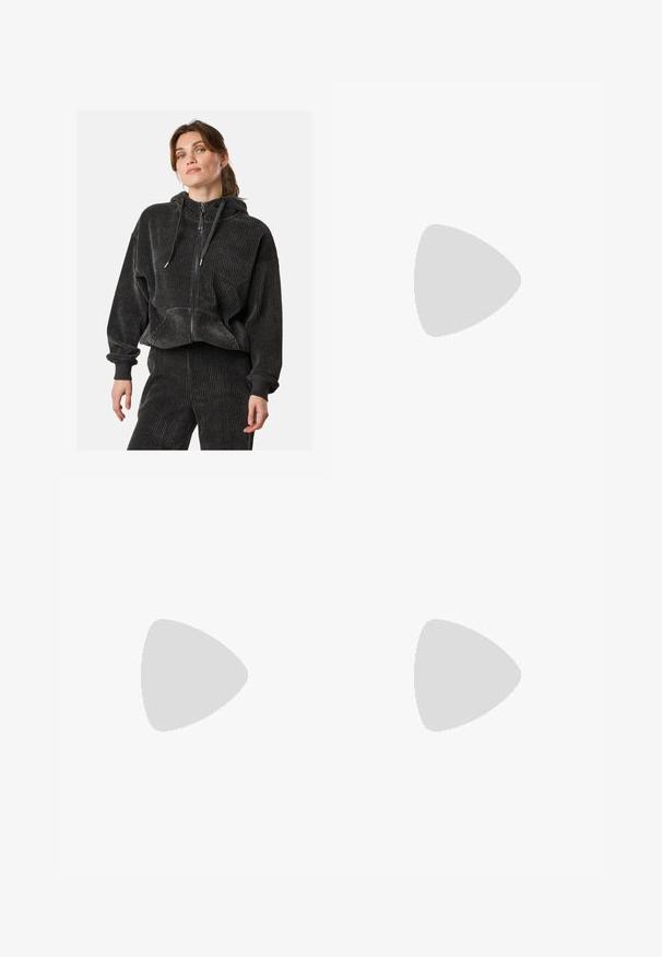 Zwarte corduroy zip-up hoodie met een relaxte pasvorm, geribbelde textuur, trekkoordcapuchon en voorzakken, gedragen met bijpassende broek.; Zwarte T-shirt van katoen, met korte mouwen over een witte lange mouw laag met een subtiel textuurpatroon. Ronde hals ontwerp.; Zwarte, lichte broek met een elastische tailleband en gathered enkels. De stof is glad en heeft een ontspannen, taps toelopend ontwerp.; Zwarte low-top sneaker met een gestructureerde zool, vetersluiting, suède panelen en een patroonaccent op de hiel en het zijlogo.