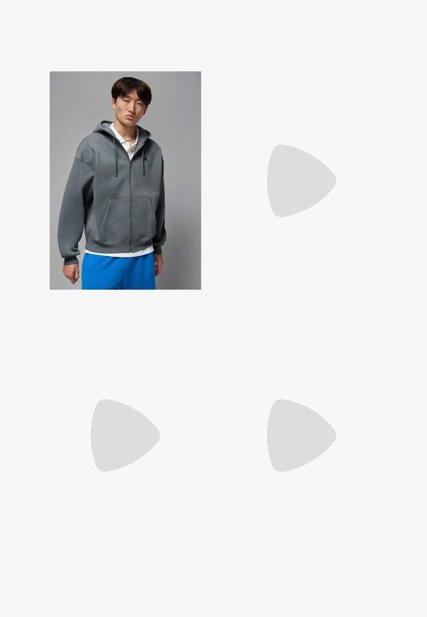 Felpa grigia con zip e tasca frontale, dotata di cappuccio regolabile e logo nero. Indossata sopra una polo bianca e abbinata a pantaloni shorts blu.; Maglietta bianca in cotone con maniche corte, scollatura rotonda, vestibilità comoda e senza loghi o motivi visibili. Texture liscia e design minimale.; Pantaloni jogger neri realizzati in tessuto morbido, dotati di una vita elastica con coulisse, polsini a costine e un piccolo logo sulla coscia sinistra.; Sneakers in pelle bianca con perforazioni, punta rotonda, suola piatta e lacci spessi, con logo swoosh visibile e "AIR" sul tallone.