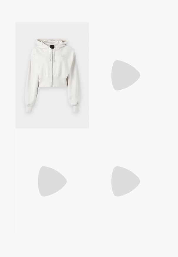 Sweatshirt à capuche coupé en beige clair. Tissu doux, zipper à l'avant, poignets côtelés, logo brodé sur le côté gauche de la poitrine.; T-shirt en coton blanc avec une coupe décontractée, des manches courtes et un petit logo brodé sur la poitrine gauche.; Pantalons de sport larges blancs avec une taille côtelée et un discret logo. Tissu lisse avec une coupe décontractée et un bas effilé.; Baskets en cuir blanc avec des accents jaunes et lavande, bout rond, lacets plats et semelle en caoutchouc texturée. Portées avec des chaussettes blanches.