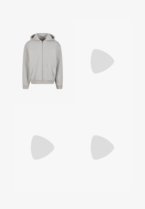 Sweat à capuche gris zippé en mélange de coton doux. Il dispose d'une capuche, de poches avant et de poignets côtelés. Design minimaliste sans motifs.; T-shirt en coton blanc avec un logo brodé bleu "Timberland Rugged Active Gear" sur le côté supérieur gauche de la poitrine. Manches courtes et col rond.; Jeans en denim noir avec une coupe droite, cinq poches et une taille classique. Le tissu a une texture lisse et un design minimaliste.; Baskets en cuir blanc avec logo Nike vert, bout rond, semelle plate, associées à un pantalon en denim bleu clair, présentées sur un tapis bleu.