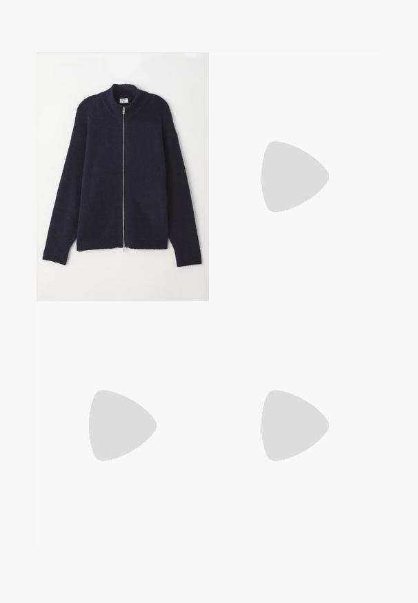 Tengerészkék zipzáras pulóver texturált kötött mintával, bordás nyakkal és fogóval, laza fazonnal és ezüst színű zipzárral.; Fehér pamut póló, kerek nyakkivágású, rövid ujjú, sima textúrájú, minta és díszítés nélküli, egyszerű kialakítás, szabványos méret.; Sötétkék farmernadrág egyenes lábbal, öt zsebbel, gombos záródással és kontrasztos varrási részletekkel.; Fekete velúr sportcipő fűzős dizájnnal és kontrasztos fehér gumitalppal. Jellemzői a textúrázott oldalpanelek és a diszkrét logó a sarokon.