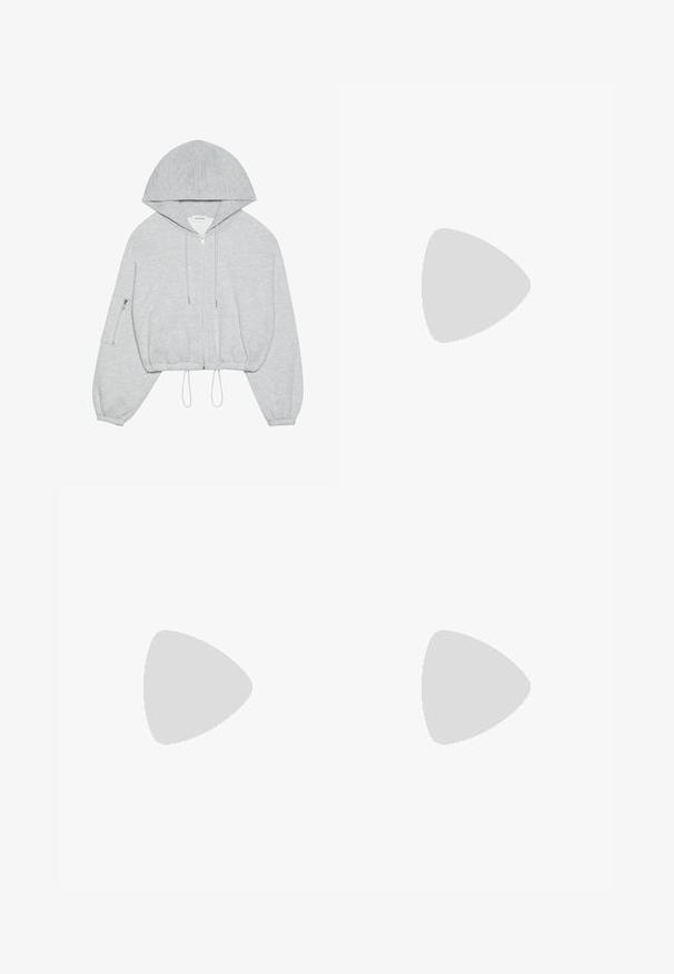 Haut à capuche gris cropped avec une fermeture éclair à l'avant, cordon de serrage à l'ourlet, grande capuche et poche zippée sur la manche gauche. Texture de tissu douce.; T-shirt en coton blanc avec un col rond et des manches courtes. Présente un petit logo Nike noir sur la poitrine. Design simple et épuré.; Pantalons de sport larges blancs avec une taille côtelée et un discret logo. Tissu lisse avec une coupe décontractée et un bas effilé.; Baskets blanches avec des accents pêche, tige en cuir lisse, bout perforé, semelle texturée et lacets. Portées avec des chaussettes blanches à mi-mollet sur une surface bleue.