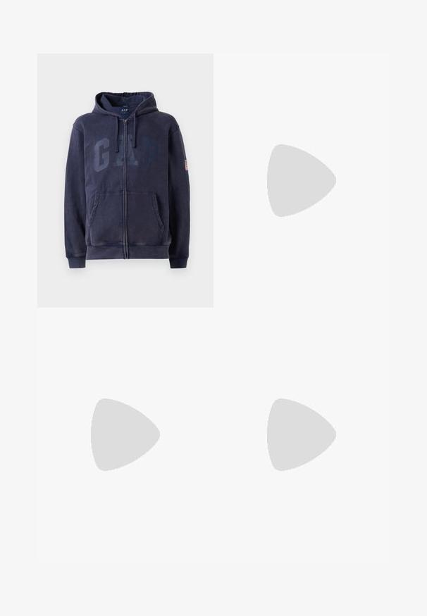 Marinblå zip-up hoodie i en bomullsblandning med stort "GAP"-logotyp fram, justerbar huva och sidofickor.; Vit t-shirt med kort ärm, tillverkad av bomull, med rund halsringning och en avslappnad passform. Slät yta utan synliga mönster eller detaljer.; Svarta byxor med plisserad design framtill, tillverkade av slätt tyg. Har en knappstängning och bälteshällor; rak passform.; Vita lädersneaker med snörning, texturerad yta och en tjock vit gummisula med ruggad kant för grepp.; Metallinramade solglasögon med ovala gröna linser. Tunn silvermetallram och svarta öronpluggar. Minimalistisk design, inga synliga logotyper.