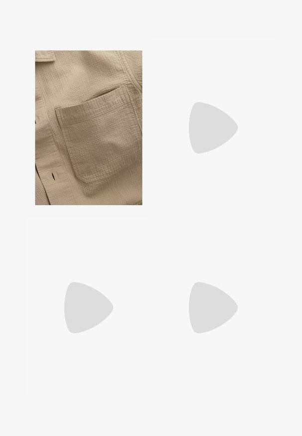 Beige strukturierte Stoffbluse mit einer quadratischen Tasche auf der linken Seite, sichtbaren Nähten und einem dezenten Karomuster.; Helles beiges Langarmhemd mit Stehkragen, Frontknopfverschluss und strukturiertem, leichtem Stoff. Gerader Schnitt am Saum.; Next REGULAR FIT - Shorts - black; Beige Wildleder-Sneaker mit runder Zehenpartie, Schnürung und strukturiertem Rückenteil. Die weiße Gummisohle sorgt für einen Kontrast. Einfaches und modernes Design.