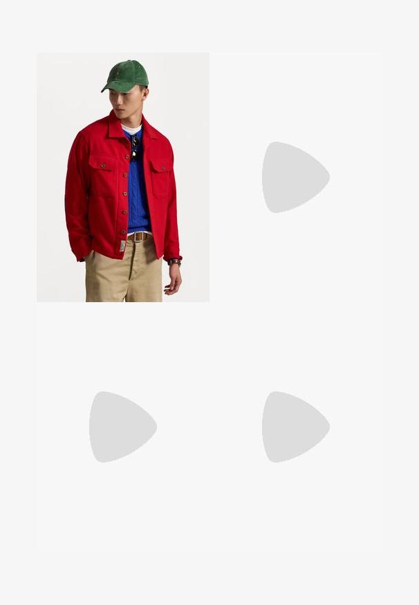 Sarkans jaku ar pogām, ar divām krūšu kabatām, virs zilā adītā džemperis, valkāts ar brūnām biksēm un zaļu kordura cepuri.; Lavandas krāsas kokvilnas t-krekls ar īsām piedurknēm, apaļu kakla izgriezumu un mazu baltu izšūtu logotipu kreisajā krūtī. Gluda, viegla auduma.; Melnas korduroja bikses ar brīvu piegriezumu, ar elastīgu jostu un auklu, kā arī sānu kabatām. Audumam ir ribota tekstūra.; Navy zila zamšas zema augstuma kedas ar baltu zoli, navy krāsas auklām un "Filling Pieces" logo zeltā sānos.