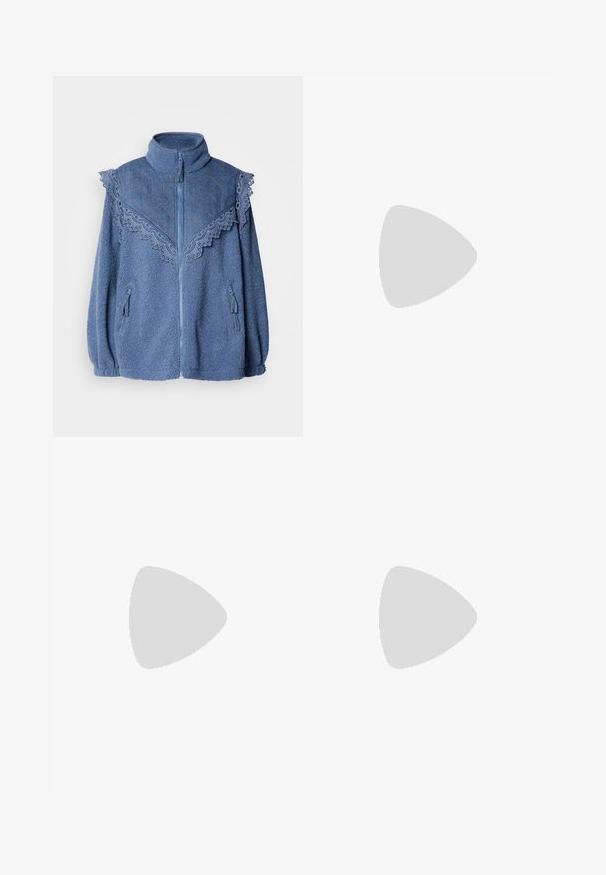 Blauwe fleecejas met een hoge kraag, voorzien van een contrasterende gebreide denim schouders en kantafwerking. Inclusief ritszakken aan de zijkanten.; Beige ribbelcardigan met lange mouwen, ronde hals en sluiting met knopen aan de voorkant, met parelachtige knopen langs de knoopsluiting.; Wijde denim jeans in donkerblauw, met een hoge taille, een bijpassende stoffen riem met een gouden gesp en versterkte stiksel details.; Tan leren cowboylaars met puntige neus, geborduurde spiraalpatronen op de schacht en een gestapelde blokhak. Voorzien van een trekband voor gemakkelijke aan- en uittrekken.; Zilveren hoop oorbellen met een gestructureerd, onregelmatig ontwerp. Het oppervlak is reflecterend en toont krommingen en contouren. De binnenruimte is hol.