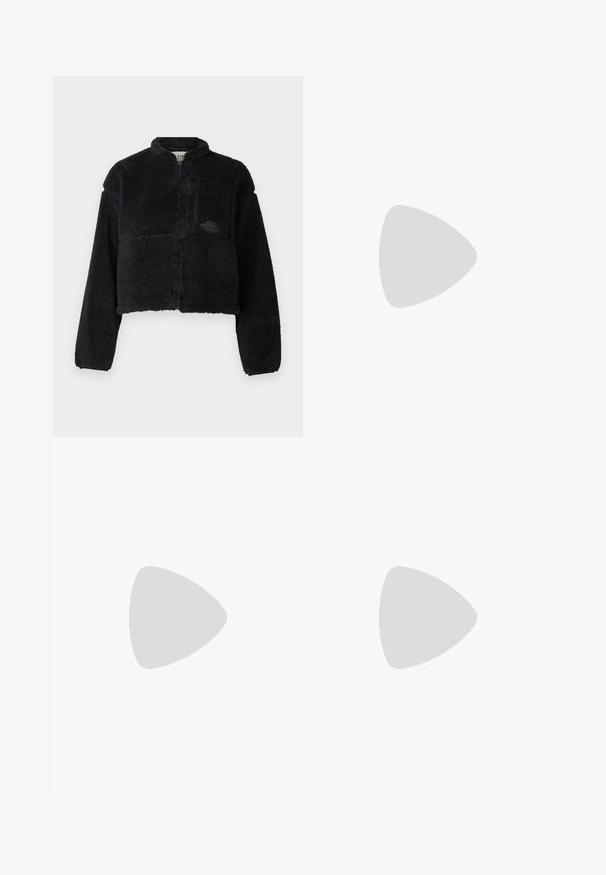 Melns vilnas žakets ar augstu apkakli, saplacinātu dizainu, garām piedurknēm, priekšējo kabatu un faktūru audumu. Iekļauj logo uz krūtīm.; Krēmkrāsas īsām piedurknēm krekls ar augstu apkakli un apļveida logotipu, kurā ir "Dickies" zilā, sarkanā un dzeltenā krāsā.; Melni denim platā kāju kravātie bikses ar augstu jostas vietu, diviem lieliem priekšējiem kabatām un pogas aizdari jostas vietā. Gluda auduma struktūra, ikdienas dizains.; Baltie un brūnie zīmējumu kedu pāris ar acs un ādas materiālu, aprīkoti ar brūniem gumijas zoliem. Saskaņotas ar gaismas bēšām platu kāju biksēm.