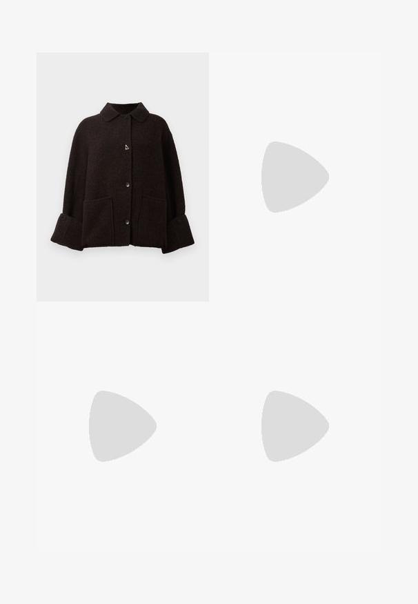 Donkerbruine wollen jas met brede manchetten, knopen aan de voorkant, twee grote zakken aan de voorkant en een puntige kraag.; Zwarte t-shirt met korte mouwen en ronde hals met een wit label binnen in de kraag, waarop "D.R.C. EST. 2002" staat, tegen een witte achtergrond.; Lichtgrijze wikkelrok met een gladde textuur, sluiting met een zijstrik en een subtiele split aan de linkerkant. Eenvoudig ontwerp zonder patronen of accenten.; Witte mesh puntige muiltjes met een slanke hak van middelgrote hoogte en een slip-on ontwerp, tegen een effen achtergrond.